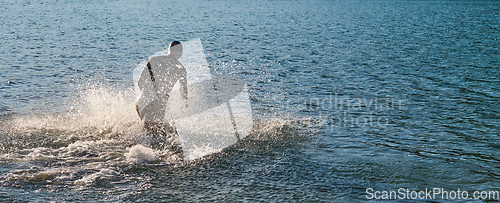 Image of Triathlon athlete starting swimming training on lake