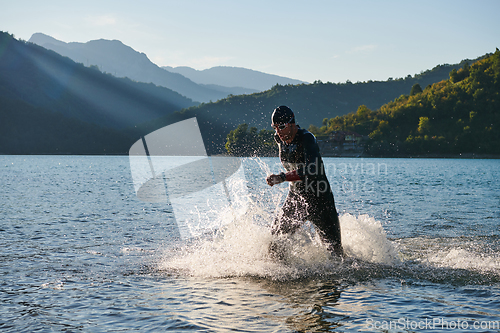 Image of Triathlon athlete starting swimming training on lake