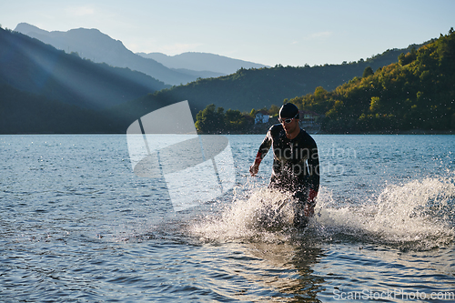 Image of Triathlon athlete starting swimming training on lake