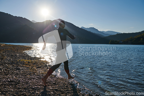 Image of Triathlon athlete starting swimming training on lake