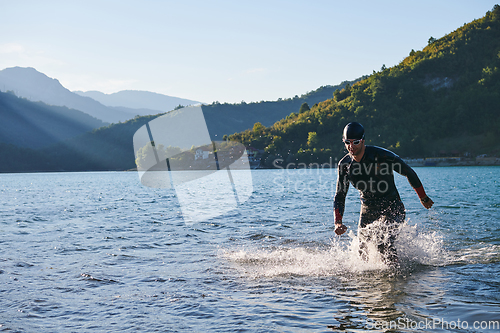 Image of Triathlon athlete starting swimming training on lake