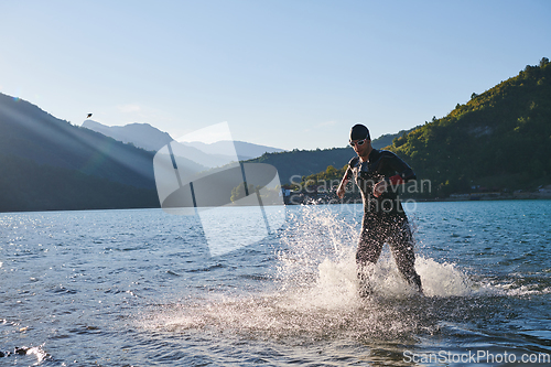 Image of Triathlon athlete starting swimming training on lake