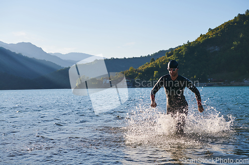 Image of Triathlon athlete starting swimming training on lake