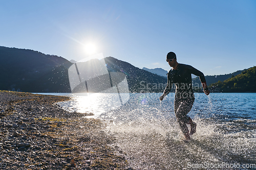 Image of Triathlon athlete starting swimming training on lake