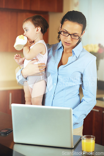 Image of Mother, baby and laptop for work from home, online planning and business research or multitasking in kitchen. Single mom or freelancer typing on computer with child care balance and project deadline