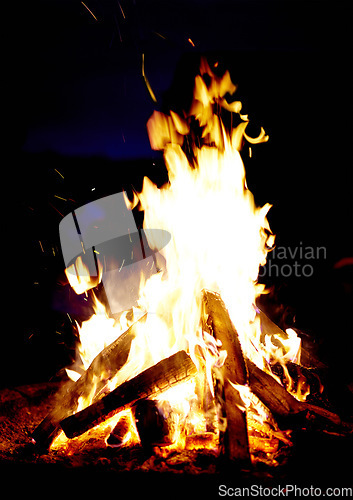 Image of Campfire, night and wood burning outdoor in nature, forest or countryside. Bonfire flame, firewood or heating, light or glow at evening campsite, hot energy or bright spark in dark woodland fireplace