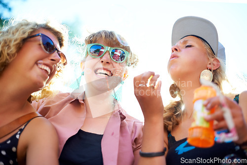 Image of Blowing bubbles, women and outdoor with friends, happiness and sunshine with fun, playing and bonding together. People, festival and group with carefree, excited and celebration with weekend break