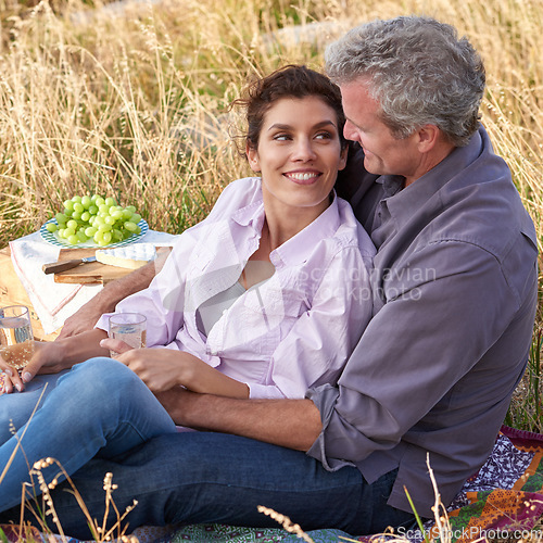 Image of Mature couple, date and picnic in park to relax with love, care or support in marriage. Outdoor, man and embrace woman on grass in nature with food, drinks or celebration together on vacation