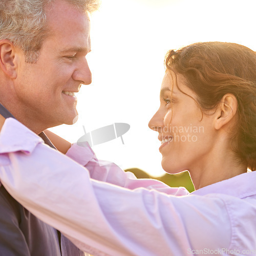 Image of Old couple, smile and embrace at sunset with love, trust and support in marriage and retirement. Happy, woman and care for partner on holiday with freedom, health and wellness at the beach for cruise