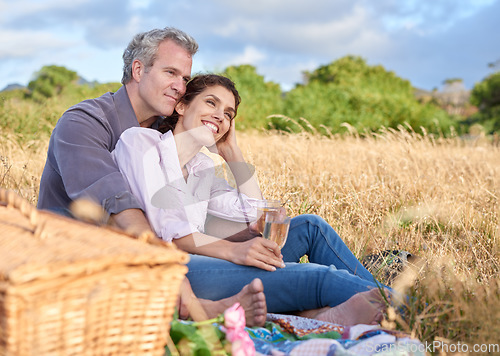 Image of Senior couple, relax and picnic in park, grass and basket in nature for a date in retirement with love or care. Mature, woman and man in field in summer, holiday or vacation with freedom and drinks