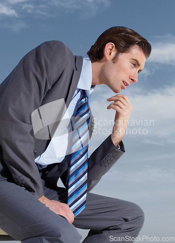 Image of Thinking, planning and a business man on a blue sky background for corporate vision or development. Profile, idea and future with a young professional employee in a suit outdoor for company growth