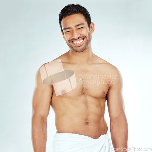 Image of Body, cleaning and happy asian man in a towel in studio for beauty, hygiene and care on grey background. Face, smile and muscular Japanese male model with glowing skin grooming results after shower