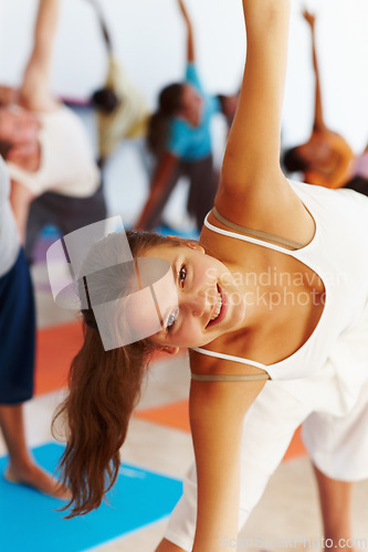 Image of Yoga, stretching and portrait of woman in triangle pose at gym, exercise and healthy body, wellness and pilates. Fitness, happy face and trikonasana, flexibility balance and class practice together