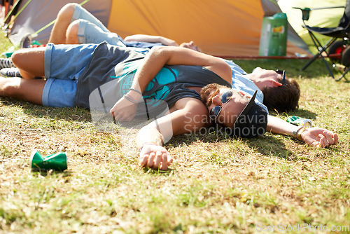 Image of Sleeping, drunk or friends on field in festival hangover in social celebration, party or concert. Fatigue, grass or tired people with alcohol drinks or can on outdoor music event or holiday vacation