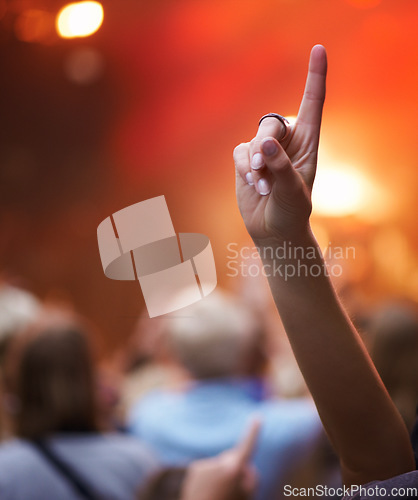 Image of Closeup, hand and person with music festival, cheering and concert with blur background, party and group. Finger, fan and sign with gesture, event and crowd with praise, celebration and performance