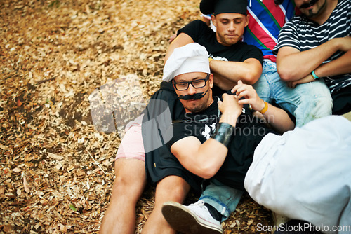 Image of Music festival, friends in costume and event with a group of young people on the ground outdoor from above. Party, summer and men lying on the ground at a show, concert or event at a summer venue