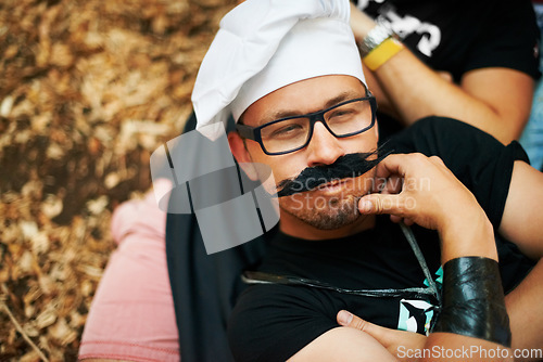 Image of Face, thinking and a man in a chef costume outdoor at a music festival for celebration or performance. Idea, relax or funny and a young person at a carnival for an event or show with his friends