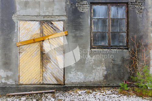 Image of Boarded-Up Door and Weathered Window on an Abandoned Buildings G