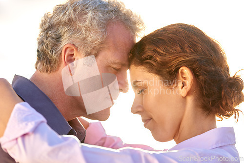 Image of Mature, couple and forehead together with love, support and care in marriage or partnership. Outdoor, man and woman with gratitude, empathy or embrace at sunset on holiday or vacation with happiness