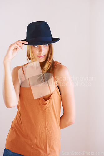 Image of Fashion, portrait and woman with hat in studio for fancy or confidence with cool outfit on wall background. Face, attitude or female model pose with bowler, clothes or vintage and retro style