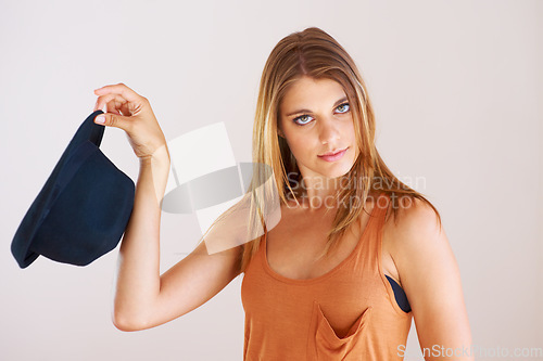 Image of Portrait, fashion and serious woman with hat in studio for style, clothing or choice on white background. Hand holding, bowler and face of female model with gesture, decision or fashionable outfit