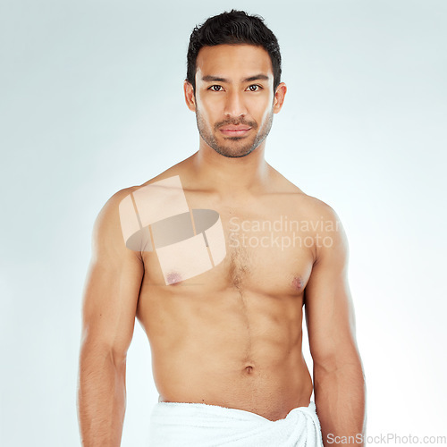 Image of Body, chest and portrait of asian man in a towel in studio for cleaning, hygiene and care on white background. Face, confidence muscular Japanese model with glowing skin grooming results after shower