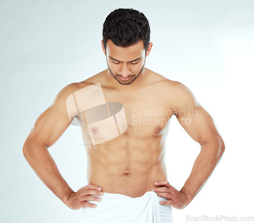 Image of Body, cleaning and asian man in a towel in studio for wellness, hygiene or grooming on white background. Stomach, chest and male model checking fitness results, progress or sixpack muscle development