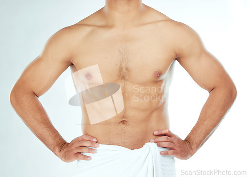 Image of Body, closeup and fitness man in a towel in studio for shower, wellness or grooming on white background. Chest, stomach and male model relax in a bathroom for cosmetic, care or cleaning with sixpack