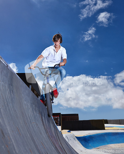 Image of Riding, bike and teen on ramp for sport performance, jump or training for event at skatepark with sky mockup. Bicycle, stunt or kid balance on edge of board in trick for cycling competition challenge