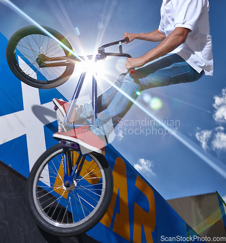 Image of Ramp, trick and man with bicycle in air at park, event or competition for sport with risk and balance. Mockup, space or person in sky with fearless stunt on bike for fun adventure or action in summer