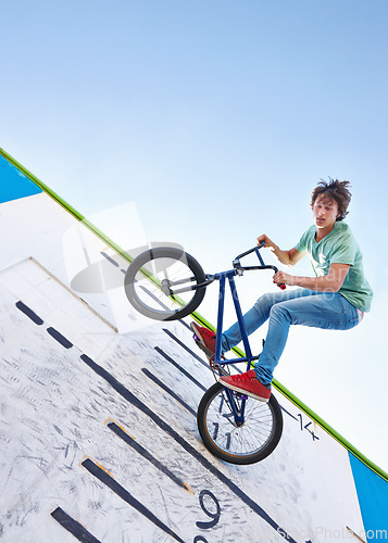 Image of Bike, trick and teenager in the air at skatepark with energy in performance for competition or event in summer. Bicycle, jump or stunt on wall with score, board and fearless freedom of cyclist in sky