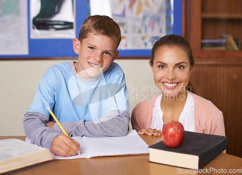 Image of Happy teacher, student and portrait in support for education, learning or tutor in classroom at school. Woman, mentor or teaching boy with smile in writing exam, literature or test for help in class