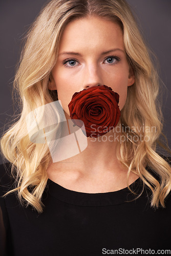 Image of Woman, face and rose in portrait, studio and floral aesthetic by backdrop or cosmetology. Female person, organic skincare and sustainable fashion or flower for romance, beauty and valentines day