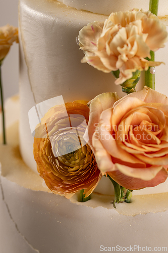 Image of Peach colored flowers in wedding cake