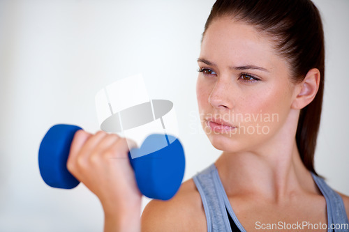 Image of Woman, serious and exercise with dumbbells in studio, health wellness and fitness for weight loss. Young person, thinking or commitment with workout for tone muscle or training on white background