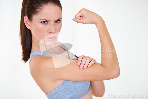 Image of Woman, portrait or serious in studio with flex for fitness, wellness or workout strength and sportswear. Person, athlete or pride for biceps, exercise or training on white background or mock up space