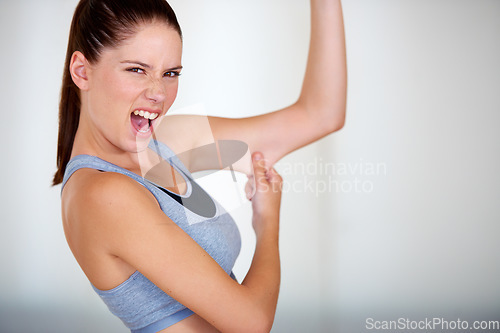 Image of Fitness, arm and woman holding her fat for health, wellness and weight loss goals in a studio. Shout, scream and portrait of young female person showing bicep body for exercise or workout motivation