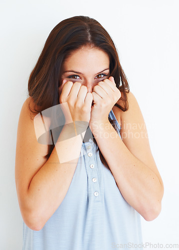 Image of Excited, hiding and portrait of shy woman with playful energy in white background of studio. Happy, emoji and person with hands to cover face for gossip story, information or reaction to drama