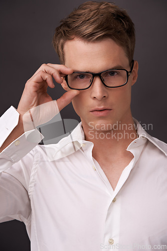 Image of Serious, nerd and portrait of man with glasses, fashion or eyewear in dark background of studio. Optometry, healthcare and geek with spectacles, style and person with prescription lenses in frame