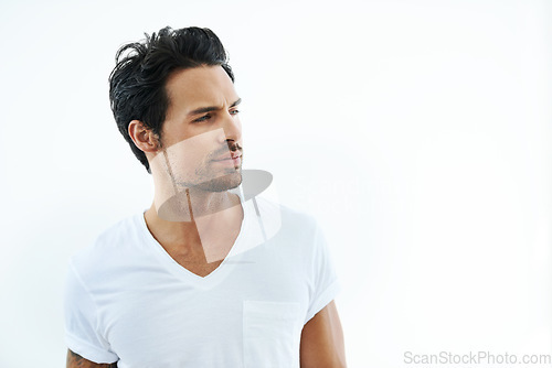 Image of Face, space and thinking with a casual man in studio isolated on a white background for contemplation. Idea, vision and future with a confident or thoughtful young person looking away in a tshirt