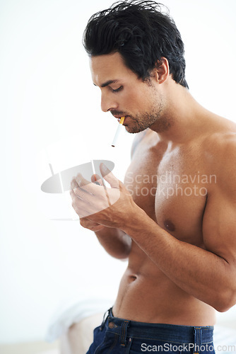 Image of Handsome man, cigarette and smoking for addiction, drag or tobacco against a white studio background. Face of young and attractive male person, model or smoker addict relax shirtless in stress relief