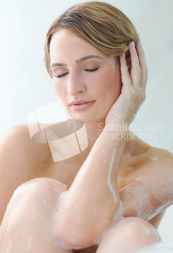 Image of Beauty, skincare or hygiene and a woman in the bath to relax while cleaning or washing her body with soap. Water, luxury and satisfaction with a person in the bathroom of her home for wellness