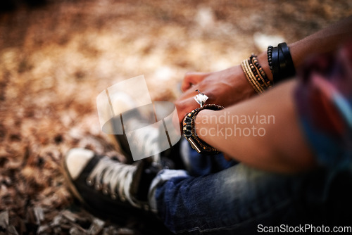 Image of Hands, relax and quiet with a person on the ground, sitting alone in autumn for peace or calm in nature. Forest, woods or wilderness with an adult closeup from above in the outdoors during fall