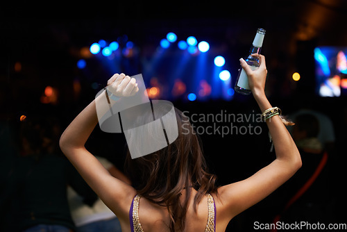 Image of Woman, back and dancing at night festival, party or music concert for DJ, performance or sound. Rear view of female person enjoying late evening entertainment at outdoor carnival, rave or audio event