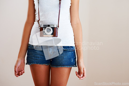 Image of Camera, woman and closeup of a photographer in studio for travel, photography or creativity. Trendy casual fashion of a female model person, student or tourist on a white background in shorts