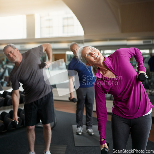 Image of Senior fitness, stretching people with dumbbells at gym for training, wellness or cardio exercise. Class, workout and elderly men with personal trainer for weightlifting club, support or bodybuilding