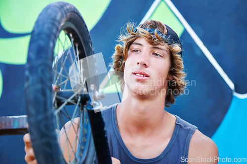 Image of Bicycle, tire and outdoor portrait of man at skatepark in summer with maintenance, repair or inspection. Bike, care and person fix wheel with wrench or cyclist check tyre for performance in cycling