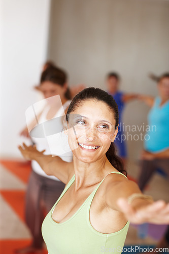 Image of Fitness, smile and yoga class with an instructor in a studio for health, wellness or holistic training. Exercise, pilates or stretching with a yogi teaching students about zen, balance or inner peace