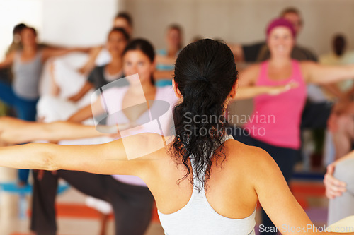 Image of Back, stretching and yoga class with an instructor in a studio for health, wellness or holistic training. Fitness, exercise and a yogi teaching a student group about zen, balance or inner peace