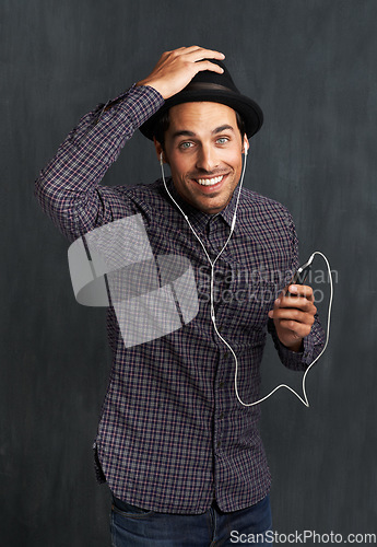 Image of Man, portrait and cellphone or earphones for music listening in studio entertainment, streaming or black background. Male person, face and hipster fashion or online indie playlist, radio or mockup